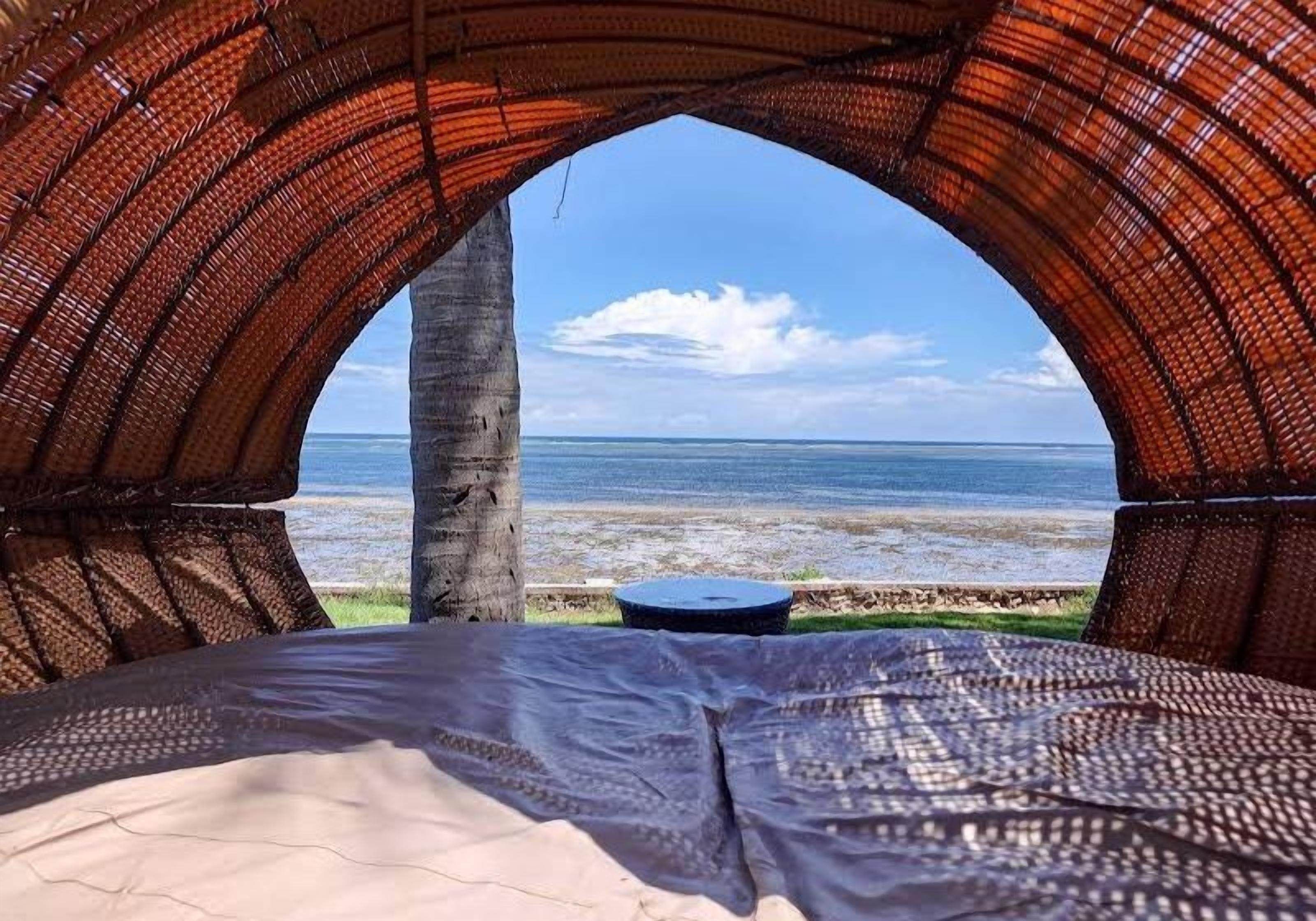Una tienda de campaña con vista a la playa y al océano.