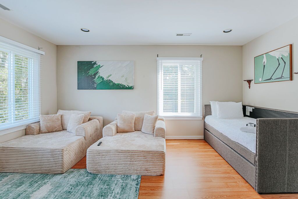 A modern bedroom with a sofa bed, a daybed, and a single bed.