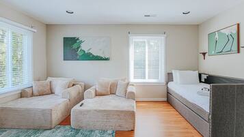 A modern bedroom with a sofa bed, a daybed, and a single bed.