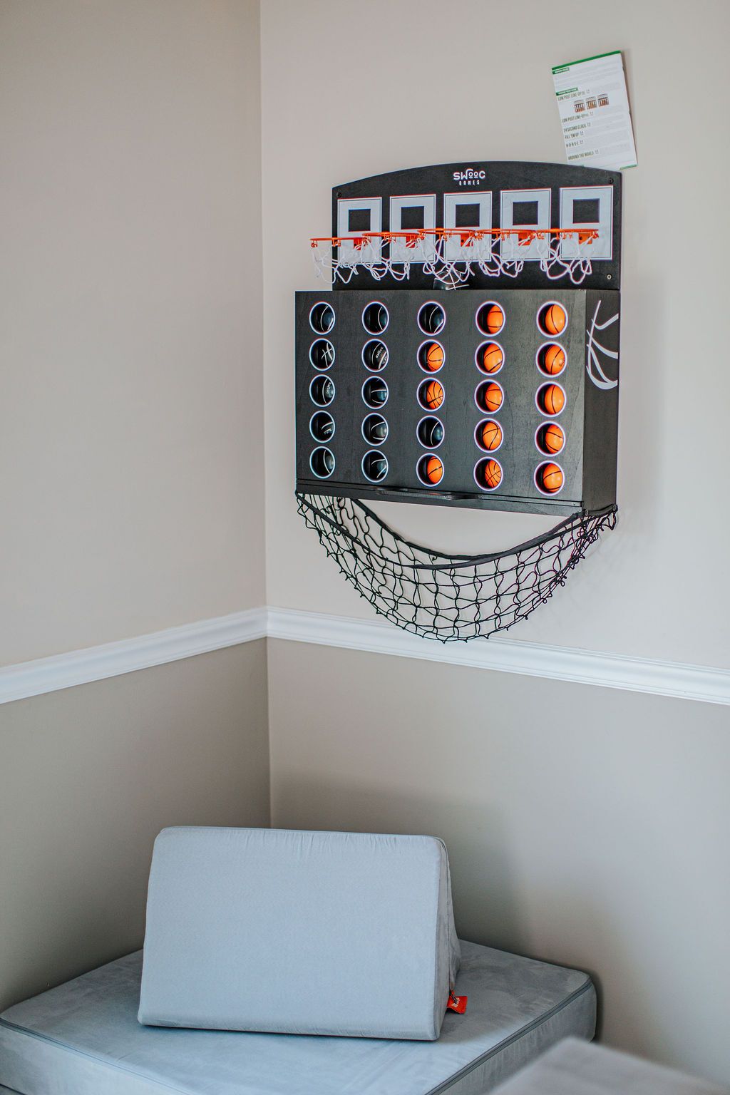 Un canestro da basket con la rete, fissato a una parete con una zoccola bianca.