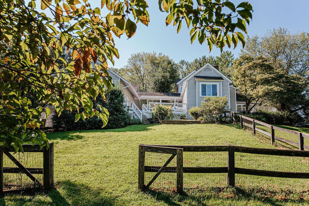 A house with a front porch, a covered entryway, and a fenced yard.
