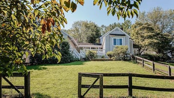 A house with a front porch, a covered entryway, and a fenced yard.