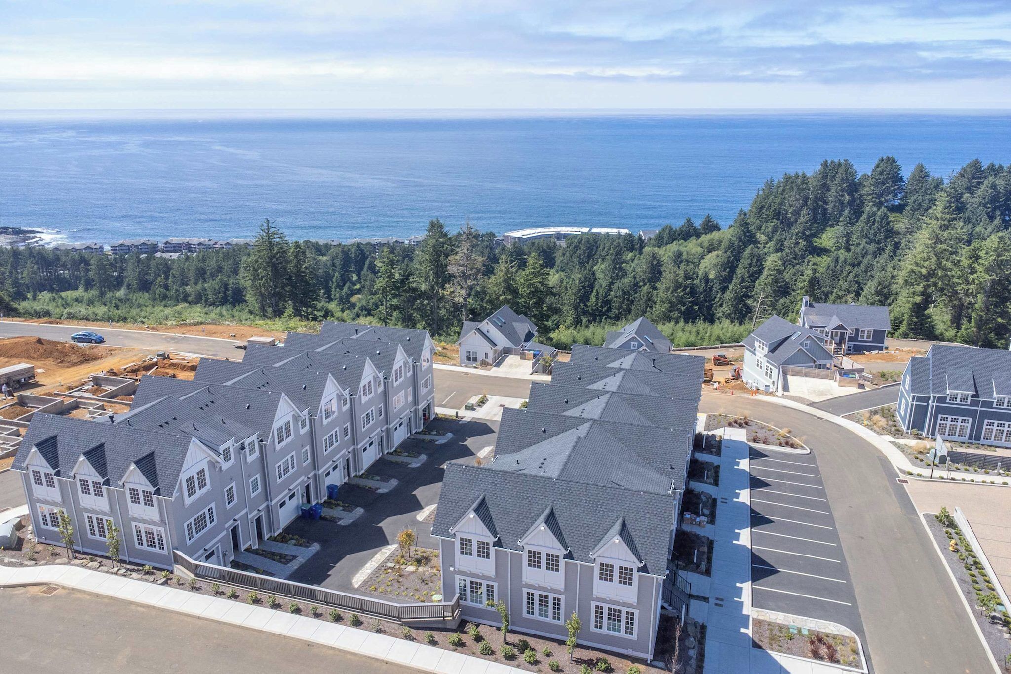 Un quartier résidentiel comprenant plusieurs maisons, un parking et offrant une vue sur l’océan.