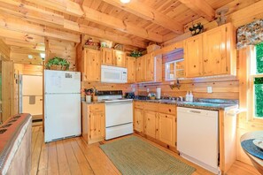 A wooden cabin interior with a kitchen area featuring wooden cabinets, a refrigerator, a microwave, a stove, and a dishwasher. - Hot Tub, Free Dollywood, Anakes, Sauna, Hot Spring (Gatlinburg)