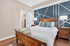 A bedroom with a wooden bed, a nightstand, a lamp, and a dresser. - Luxury Gatlinburg Condo Free Dollywood w/ Sauna (Gatlinburg)