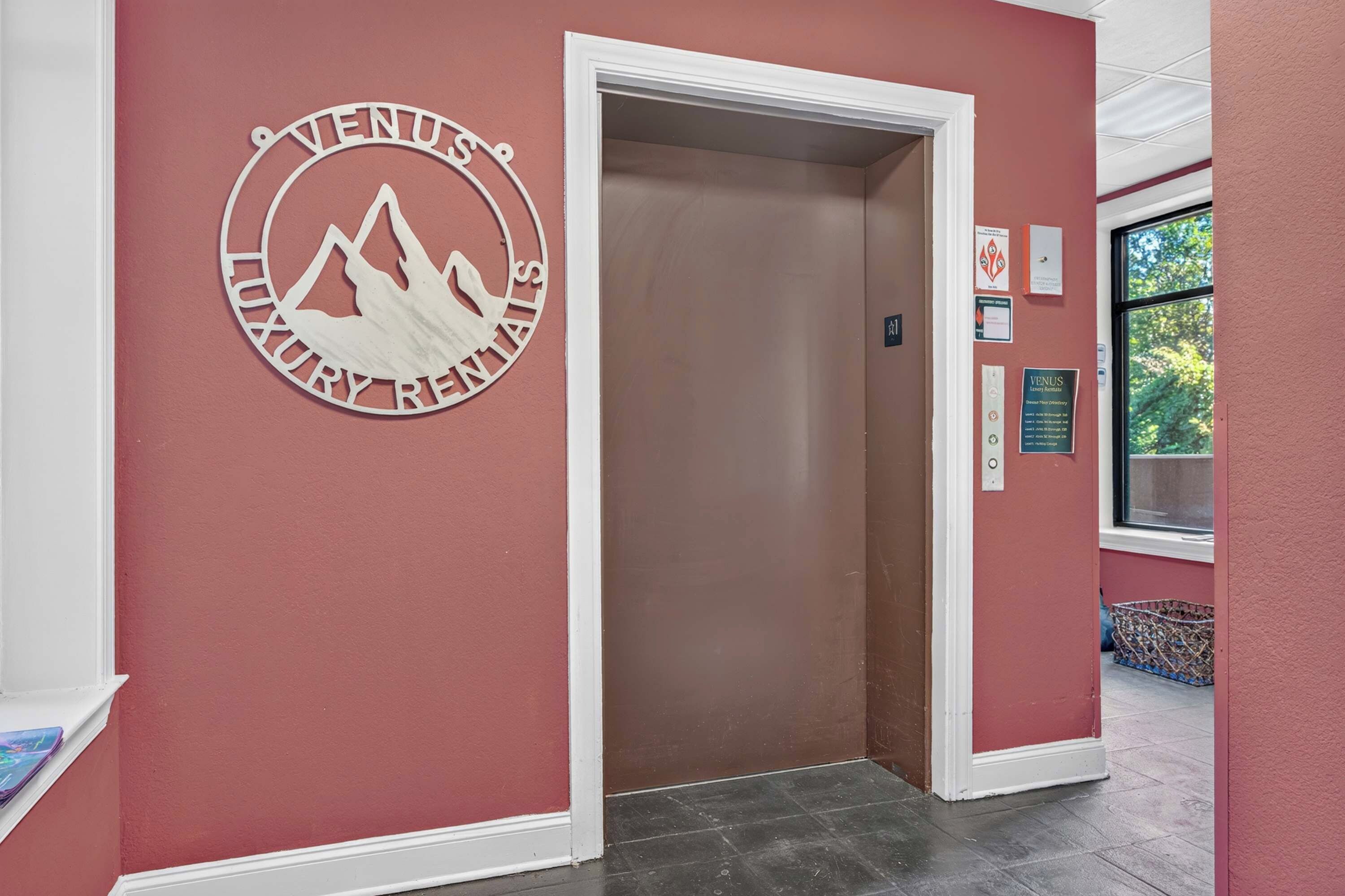 A hallway with a red wall, a white door, and a sign for 'Venus Luxury Retreats'.