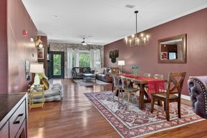 A spacious living room with a dining area, hardwood floors, and a fireplace. - Luxury, Views, Free Tickets, Saunas, Arcade, Peace (Gatlinburg)