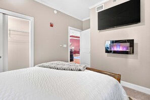 A bedroom with a bed, a television mounted on the wall, and a door leading to another room. - Sauna & Spa Paradise 1 Mi from Downtown Gatlinburg (Gatlinburg)