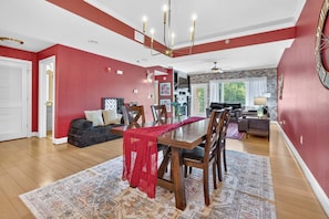 A dining area with a wooden table and chairs, a red throw on the table, and a patterned rug on the floor. - Sauna & Spa Paradise 1 Mi from Downtown Gatlinburg (Gatlinburg)