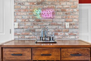 A brick wall with a neon sign that reads 'HAPPY HOUR' and a bar setup with a cocktail shaker and glasses. - Sauna & Spa Paradise 1 Mi from Downtown Gatlinburg (Gatlinburg)