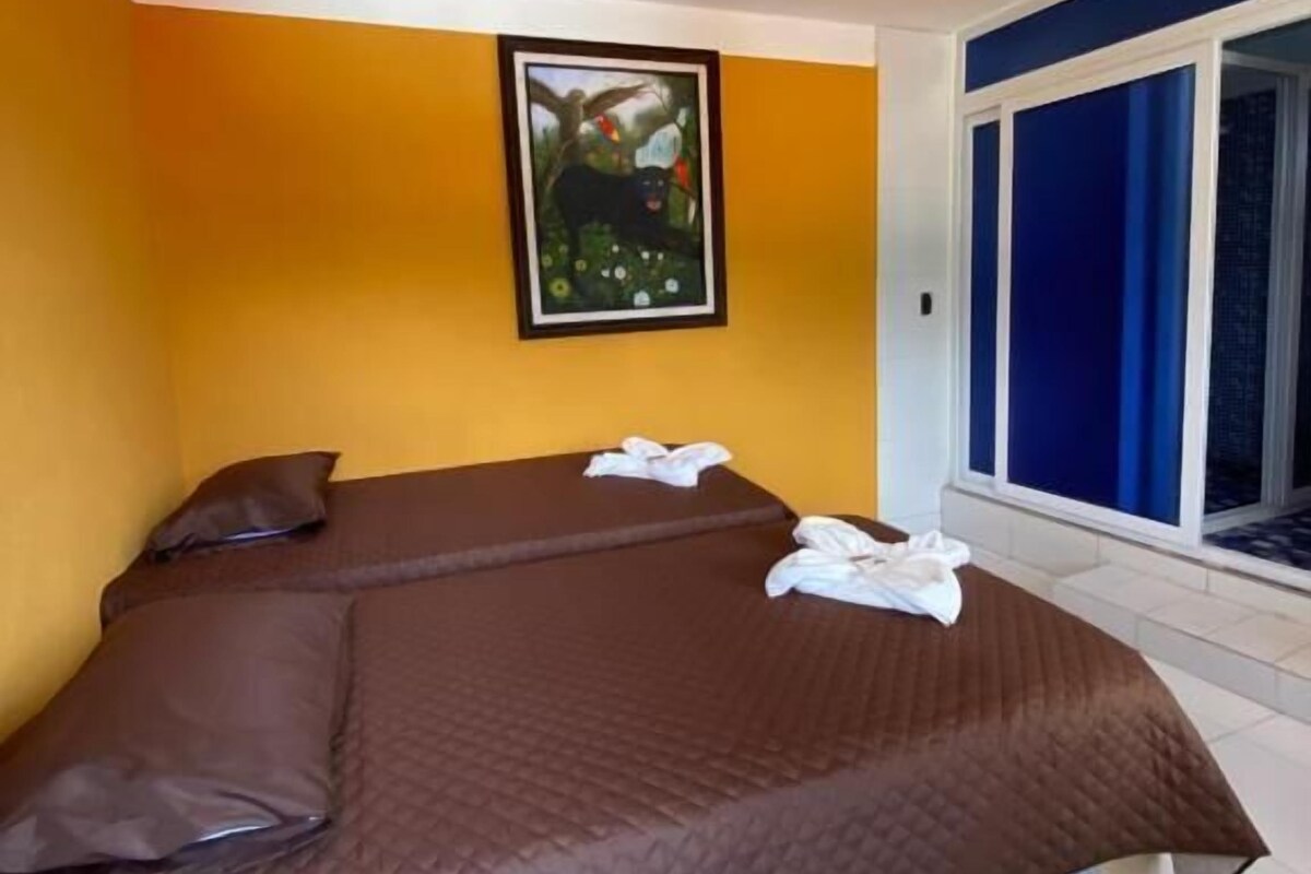 Una camera da letto con un letto, un quadro appeso al muro e una finestra con tende.
