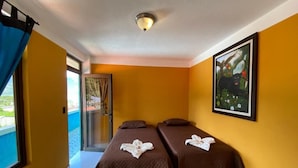 Ein Hotelzimmer mit zwei Betten, einem Balkon und einem Gemälde an der Wand.