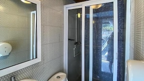 Ein Badezimmer mit einem weißen Waschbecken, einer Toilette und einer Duschkabine.