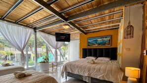 Ein Hotelzimmer mit Bett, einer Couch, einem Fernseher und einem Gemälde an der Wand.