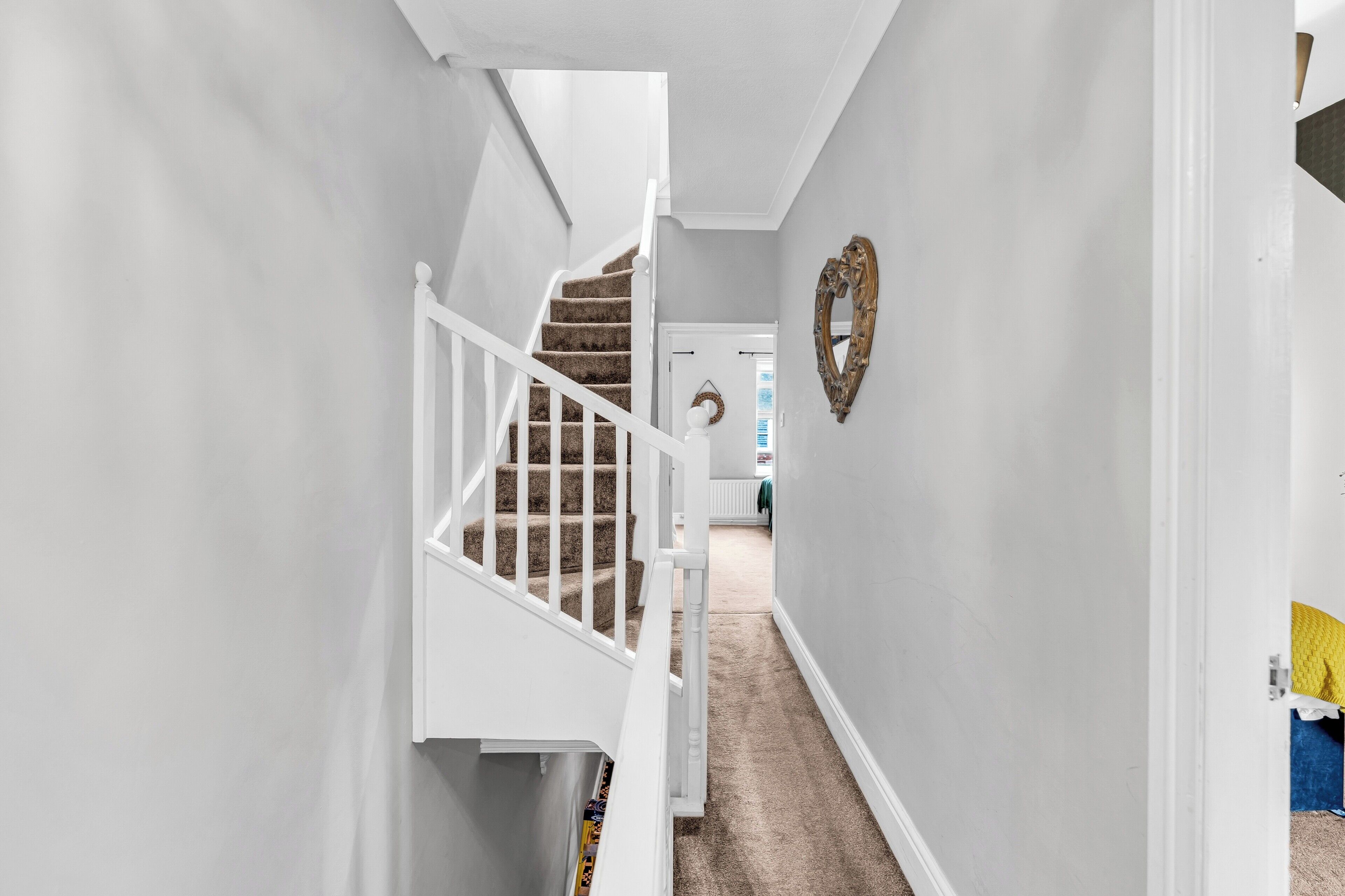 A hallway with a staircase leading to a room.