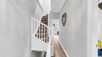 A hallway with a staircase leading to a room.