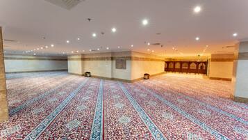 Un vaste hall doté d’un tapis à motifs, d’un éclairage encastré et d’un espace central agrémenté d’un mur à motifs.