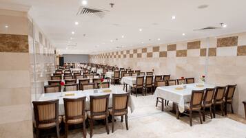 A spacious dining area with multiple tables and chairs, arranged in rows.