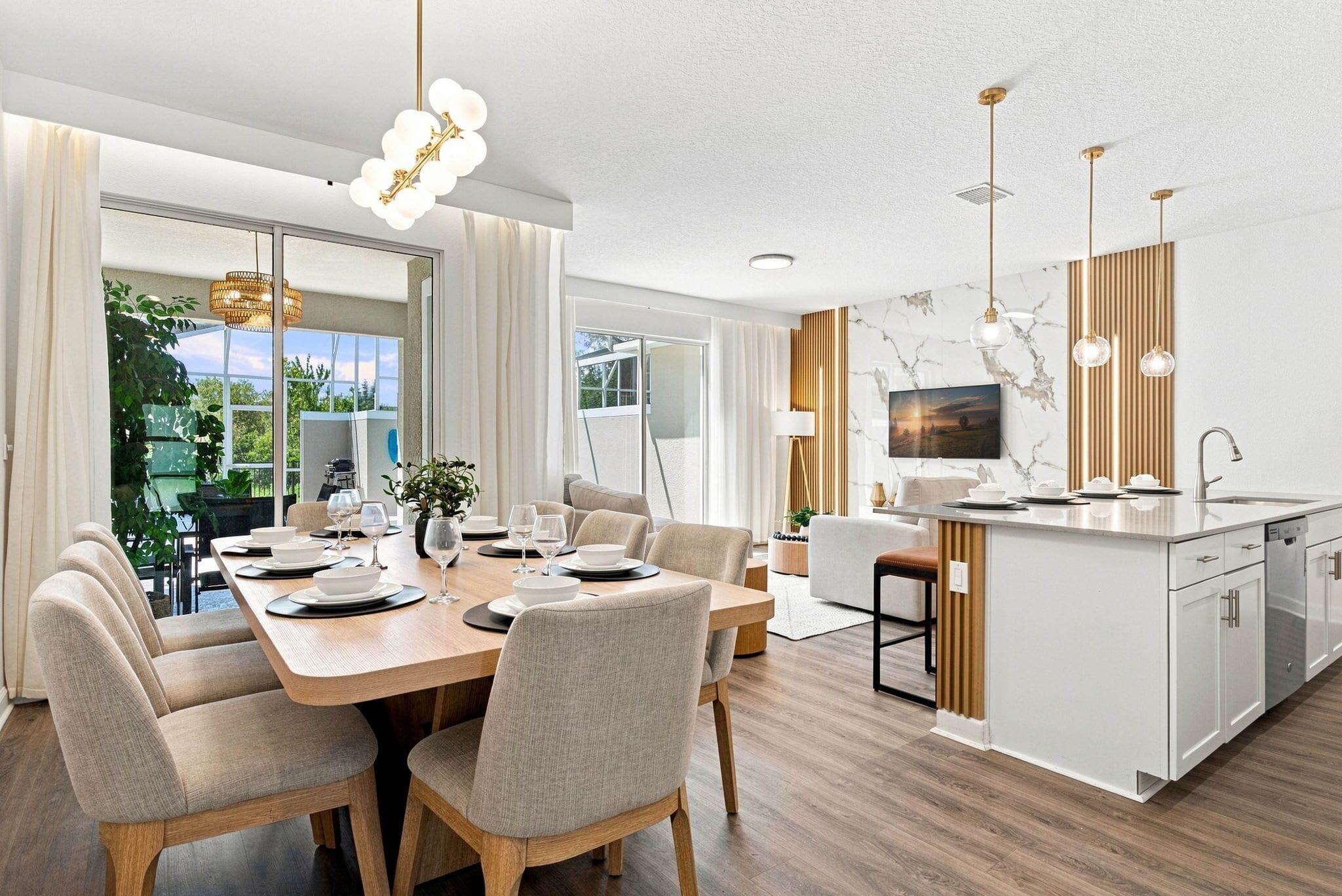 A modern kitchen with a marble backsplash, a dining area with a wooden table and chairs, and a large window providing a view of the outdoors.