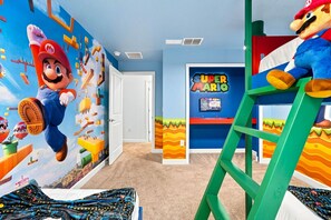 Ein Zimmer mit Wandmalerei zum Thema Mario, einer Leiter und einem Super-Mario-Schild.