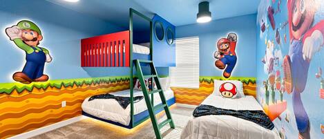 Un dormitorio infantil con dos camas, una litera y decoración de pared con temática de Mario.
