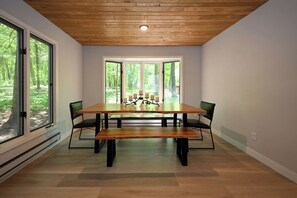 A dining area with a wooden table, four chairs, and a bench. - Winter Getaway at Northern Lights Lodge (Spooner)