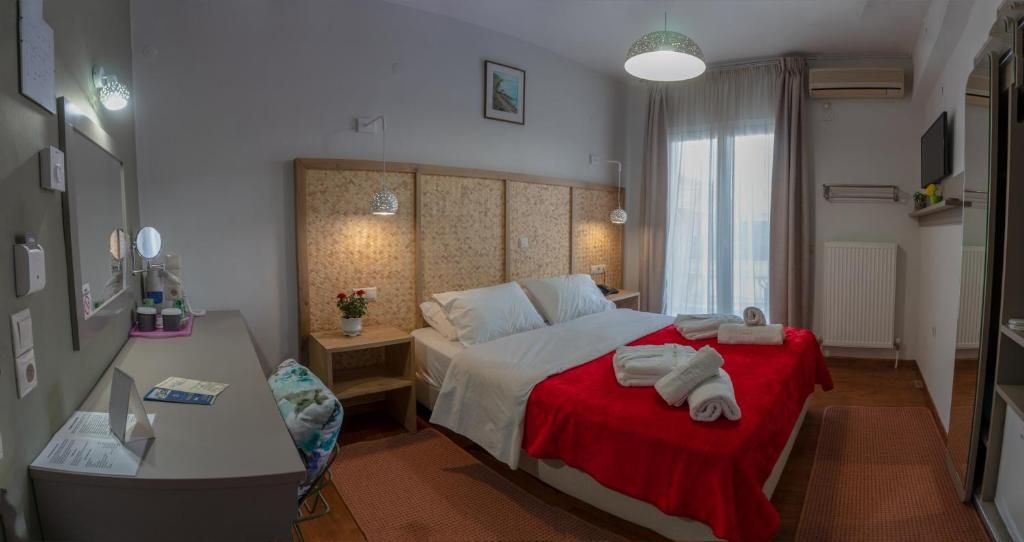 A hotel room with a bed, bedside table, lamp, and a desk with a chair.