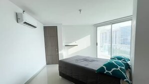 Ein Schlafzimmer mit Bett, Fenster und Klimaanlage.