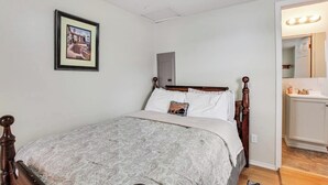 A bedroom with a bed, a bedside table, a mirror, and a framed picture on the wall. - Secluded 1BR Lakefront - Dock - Deck (Port Angeles)