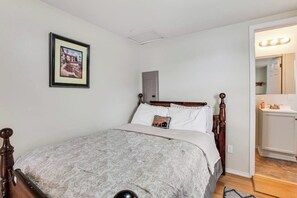 A bedroom with a bed, a bedside table, a mirror, and a framed picture on the wall. - Secluded 1BR Lakefront - Dock - Deck (Port Angeles)
