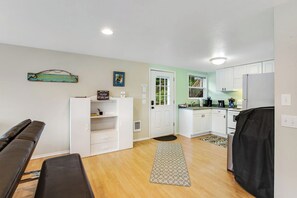 A compact kitchen with white cabinets, a refrigerator, and a coffee maker. - Secluded 1BR Lakefront - Dock - Deck (Port Angeles)