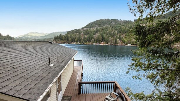 A deck with a view of a lake and forested hills. - Secluded 1BR Lakefront - Dock - Deck (Port Angeles)