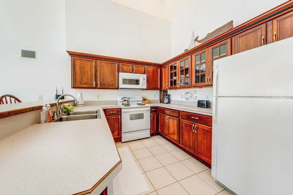 A kitchen with wooden cabinets, a white refrigerator, a microwave, and a stove.
