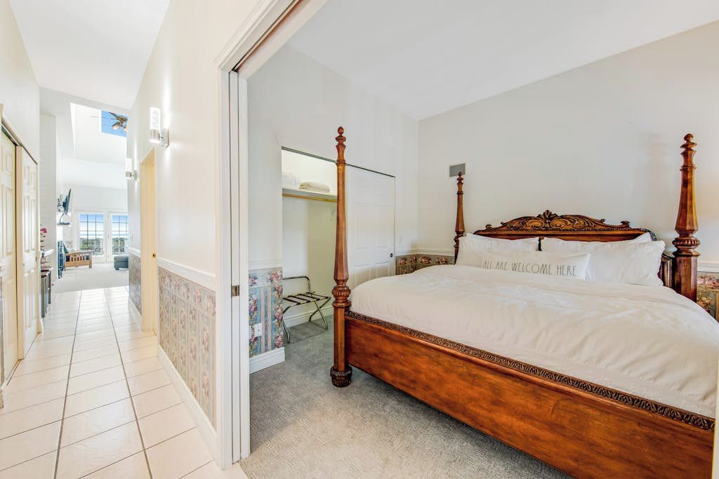 Un dormitorio con cama con dosel, vestidor y vista al área social.
