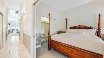 Un dormitorio con cama con dosel, vestidor y vista al área social.