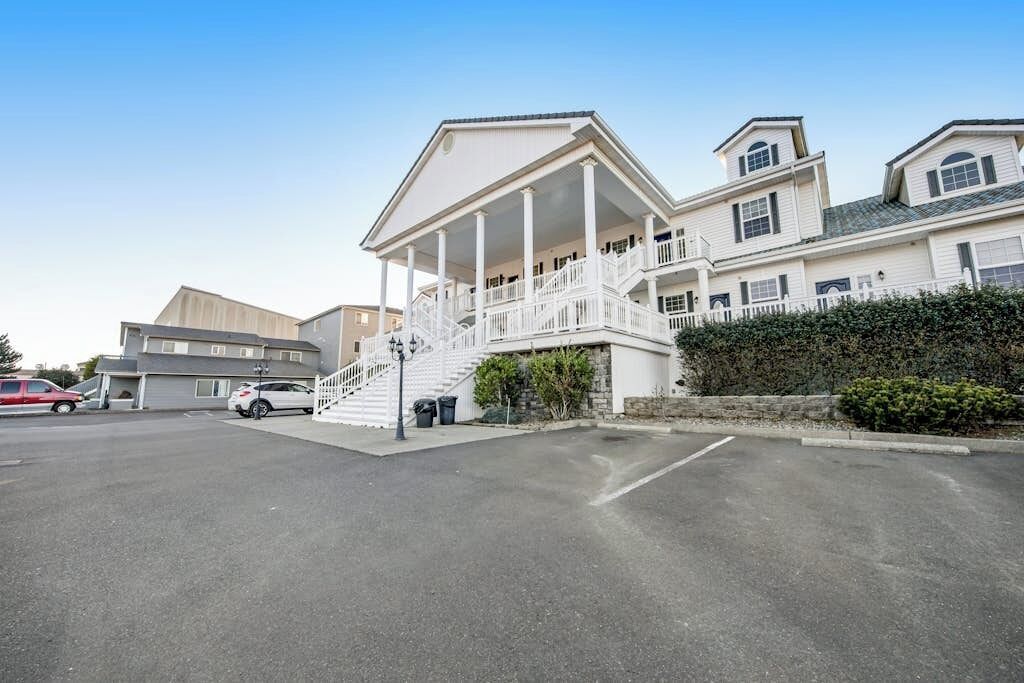 A multi-story building with a central staircase and a covered porch.