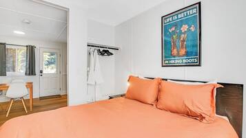 Une chambre à coucher avec un lit, une armoire, un bureau et une affiche accrochée au mur.