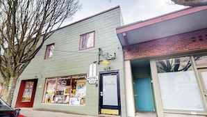 A hotel with a sign indicating it is a hotel, a storefront with photography and fine art printing services, and a closed garage door. - 1BR Hotel Room right in Downtown Port Townsend (Port Townsend)