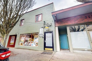 Een hotel met een bord waarop staat dat het een hotel is, een winkel met fotografie en dienstverlening voor het printen van kunst, en een gesloten garage.