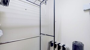 A room with a metal rack, a white wall, and a black object on the right. - 1BR Hotel Room right in Downtown Port Townsend (Port Townsend)