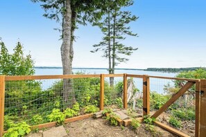A wooden fence with a view of a lake and trees. - 2BR Oceanview Birch Bay Dog Friendly - Patio (Blaine)