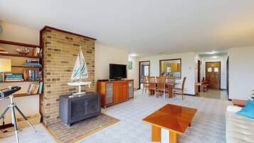 Una sala de estar con chimenea, televisión y una decoración con un velero.