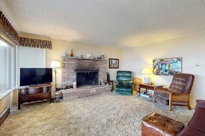 A living room with a fireplace, television, and comfortable seating.