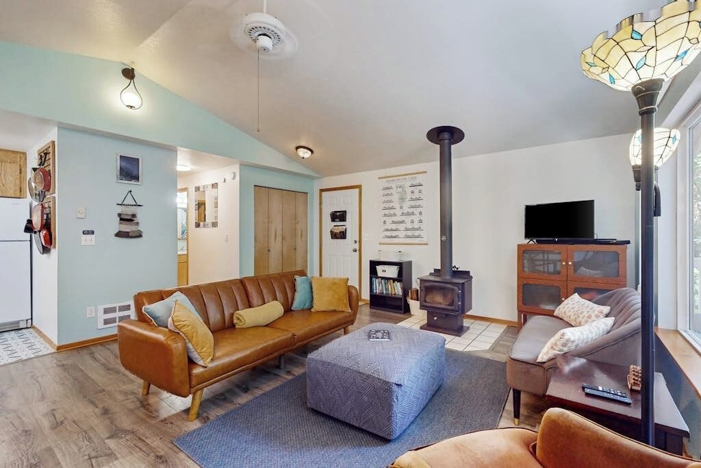 Ein gemütliches Wohnzimmer mit einer Couch, einem Hocker und einem Kamin.