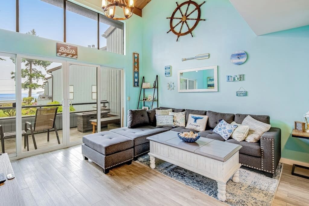 Una sala moderna con un amplio sofá modular, una mesa de centro y vistas al exterior.