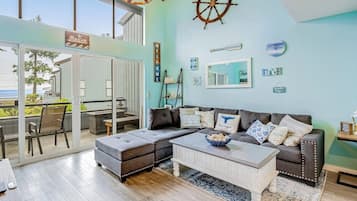 Una sala moderna con un amplio sofá modular, una mesa de centro y vistas al exterior.