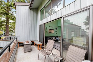 Un patio al aire libre con un banco de madera, una mesa y dos sillas.