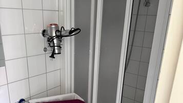 Ein Badezimmer mit Dusche, Handtuchhalter und Toilette.
