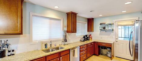 A kitchen with wooden cabinets, a stainless steel sink, and a built-in oven.
