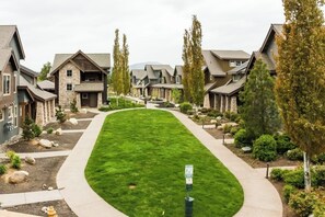 A residential area with multiple houses, a well-maintained lawn, and a clear pathway. - Spacious 4BR Waterview Suncadia Resort (Cle Elum)